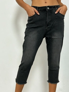 Detail of high waist charcoal black skinny jeans featuring unique raw frayed hems