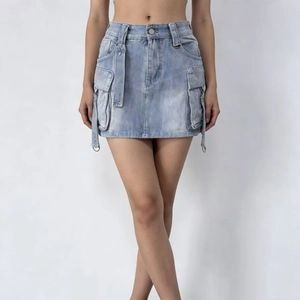 Dettaglio minigonna in denim azzurro con ampie tasche cargo e lunghi cinturini decorativi