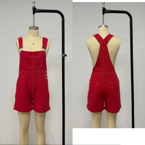 Detail of red utility denim overalls with contrast stitching and multi-pocket design