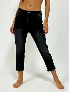 Close-up of raw hem detail on high-waisted black cropped stretch denim jeans