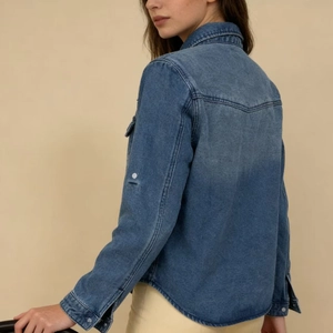 Detail of blue wash denim shirt back with classic V-yoke and curved hemline