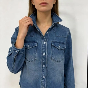 Detailed close-up of dark blue denim shirt with chest pockets and white buttons