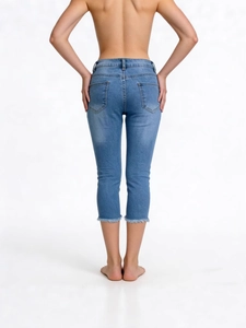 Back view of slim fit light blue cropped denim jeans with raw hem and wash effect