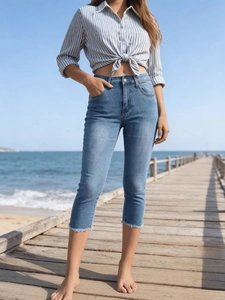 Slim fit high-waisted cropped blue denim jeans with frayed hems for casual wear
