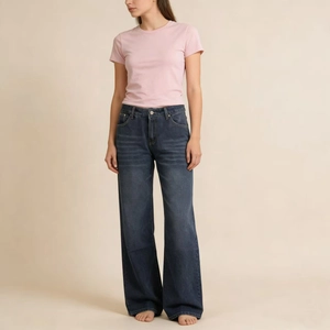 Detail of wide-leg dark blue denim jeans with washed texture and cat whisker patterns