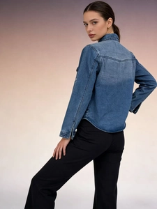 Women's casual blue denim shirt with high waist black pants shown from side-back view