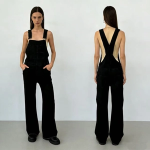 Détails des boucles métalliques et de la poche bavette sur la salopette en jean noir