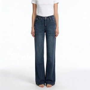 Detail of dark blue wide leg jeans featuring vintage wash effect and whisker texture
