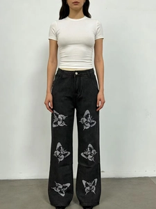 Détail d'un jean taille haute gris foncé à jambe large avec imprimés artistiques de papillons