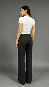 Détail du jean droit ample à taille haute avec poches arrière sur un mannequin
