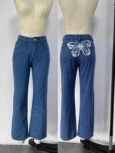 Detail einer High-Waist-Jeans in Blau mit weißem Schmetterlingsdruck auf den Rücktaschen