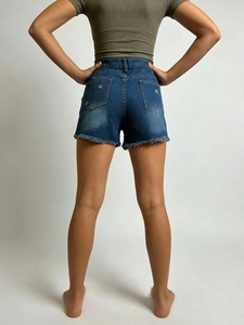 Détail du short en jean taille haute avec ourlets effilochés et poches arrière usées
