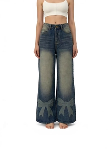 Women high waisted wide leg washed jeans with large green bow prints on a white background