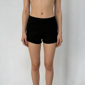 Detail of high-waisted black slim fit stretch denim shorts for women in plain black