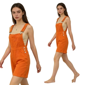 Detail of orange denim overalls featuring adjustable metal buckles and large front pocket