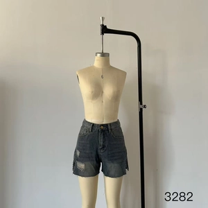 Detailed view of high-waist denim shorts featuring raw hems and distressed details
