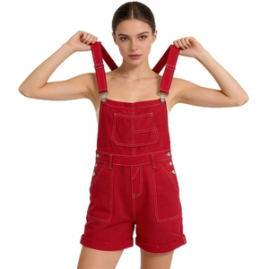 Detail view of red denim overalls with adjustable metal buckles and stitching details