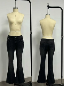 Detail view of charcoal grey flare jeans with washed denim texture and five-pocket design