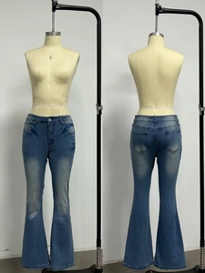 Close-up of retro washed flared jeans showing faded details and wide leg cut on a mannequin