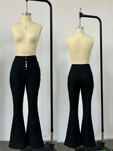 Détail du jean évasé noir à taille haute avec une fermeture élégante à quatre boutons