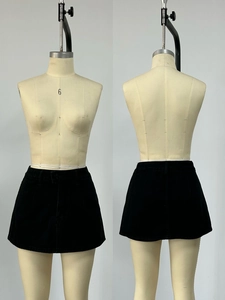 Dettaglio fronte e retro di una minigonna in denim nero a trapezio con passanti per cintura