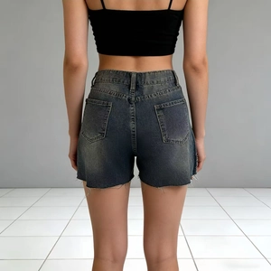 Detail of high-waist dark blue denim shorts featuring frayed edges and back pockets
