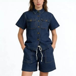 Detail of dark blue denim set featuring a short-sleeve work shirt and drawstring shorts
