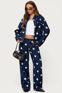 Détail d'un ensemble en denim bleu foncé à pois bleu clair avec veste et pantalon large