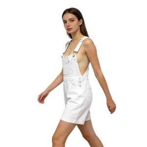 Side view of white denim overalls showing metal buttons and durable cotton texture
