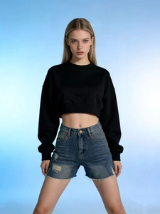 Detailed view of high-waisted frayed denim shorts with distressed holes and raw hem design