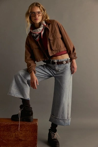 Jeans larghi azzurri lavati retrò con giacca utility marrone e orli con risvolto ampio
