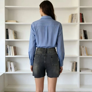 Back view of women's casual frayed denim shorts with light blue striped shirt
