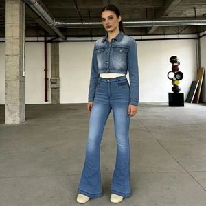 Detail view of retro washed denim flare pants and matching jacket on a model