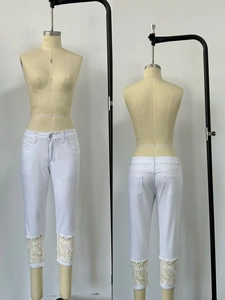 Vue détaillée du jean court blanc avec ourlet en dentelle crochetée élégante et large