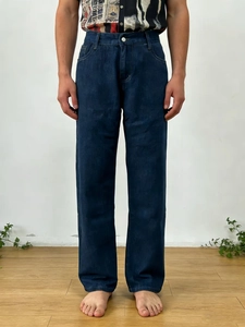 Détail du pantalon en jean bleu foncé avec texture de tissu épaisse et bouton de taille
