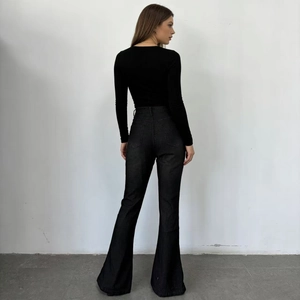 Rear view of high waisted black flare jeans and slim long sleeve top on a model