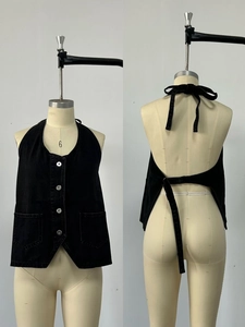 Detail view of black denim halter vest with front buttons and back tie closure details