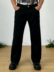 Détail d'un jean noir coupe droite classique avec fermeture à bouton argenté métallisé