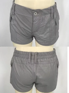 Detail of grey casual shorts featuring side flap pockets and elastic waistband design