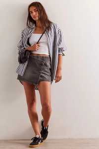 Detailansicht des asymmetrischen Knopfverschlusses am dunkelgrauen Jeansrock