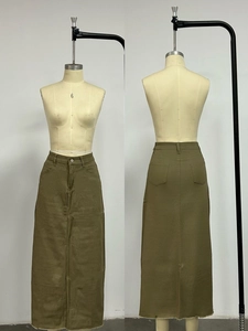Detail of high-waisted khaki denim skirt featuring a raw hem and multi-pocket structure