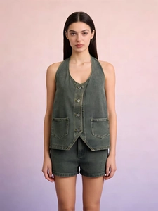 Detail of vintage washed green denim vest with halter neck and button front closure
