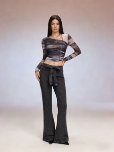 Detail of high waist flared jeans with a matching fabric tie belt for a modern style