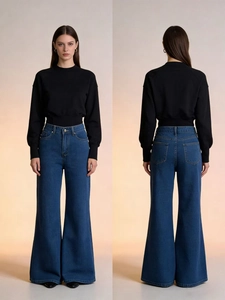Detail view of high-waisted flared denim jeans in washed blue with a loose wide-leg fit