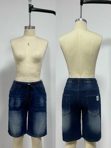 Detail view of deep blue denim shorts featuring elastic drawstring waist and whiskering