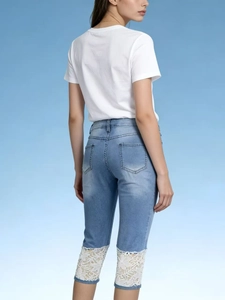 Women's light blue washed jeans with elegant white floral lace panels on the back