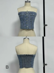 Detail of light blue denim tube top with metal buttons and frayed hem edge