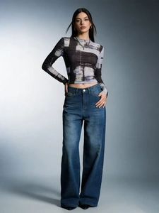 Detail view of high waist loose wide leg jeans and abstract patterned patchwork top