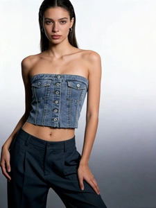 Detail of blue denim bustier top with button front, flap pockets and raw hemline