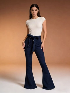 Close-up of high-waist flare jeans with tie-knot fabric belt and slim fit white t-shirt